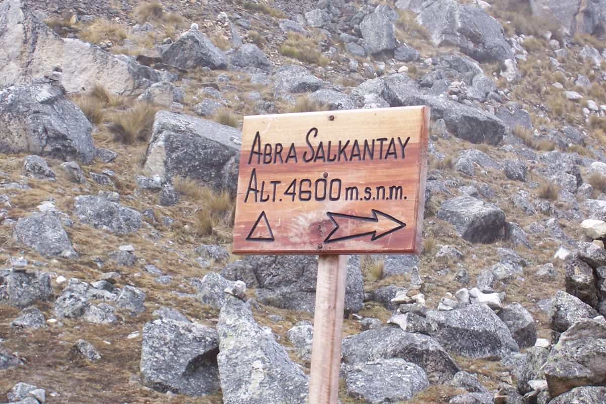 Trekkers crossing the stone-marked Salkantay Pass below the glacier